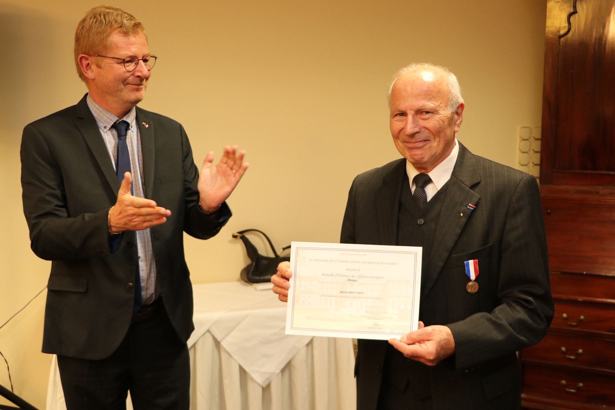 Der französische Generalkonsul im Saarland, Sébastien Girard, überreicht Honorarkonsul a.D. Michel Bouchon die Ehrenmedaille, die er vom französischen Außenminister verliehen bekam. Foto: Sascha Schmidt